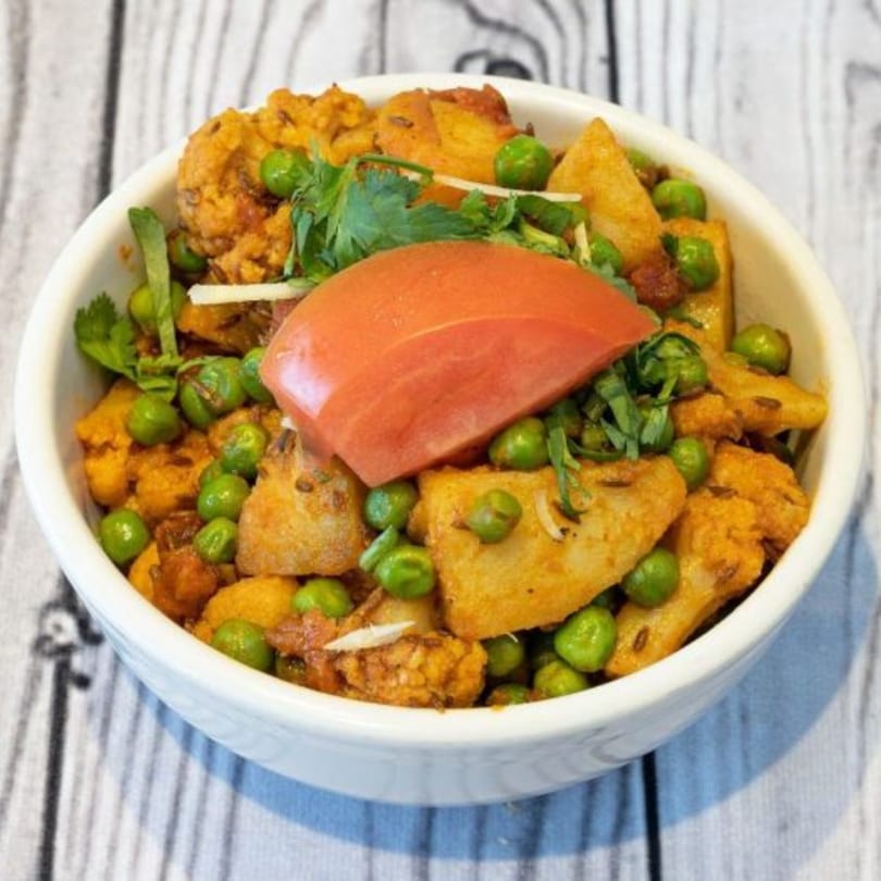 Aloo Gobi Matar from The Kurrywala Co., with potatoes, cauliflower, peas, and a tomato slice.